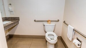 Ein kleines, sauberes Badezimmer mit Toilette, Handtuchhalter und Waschbecken.