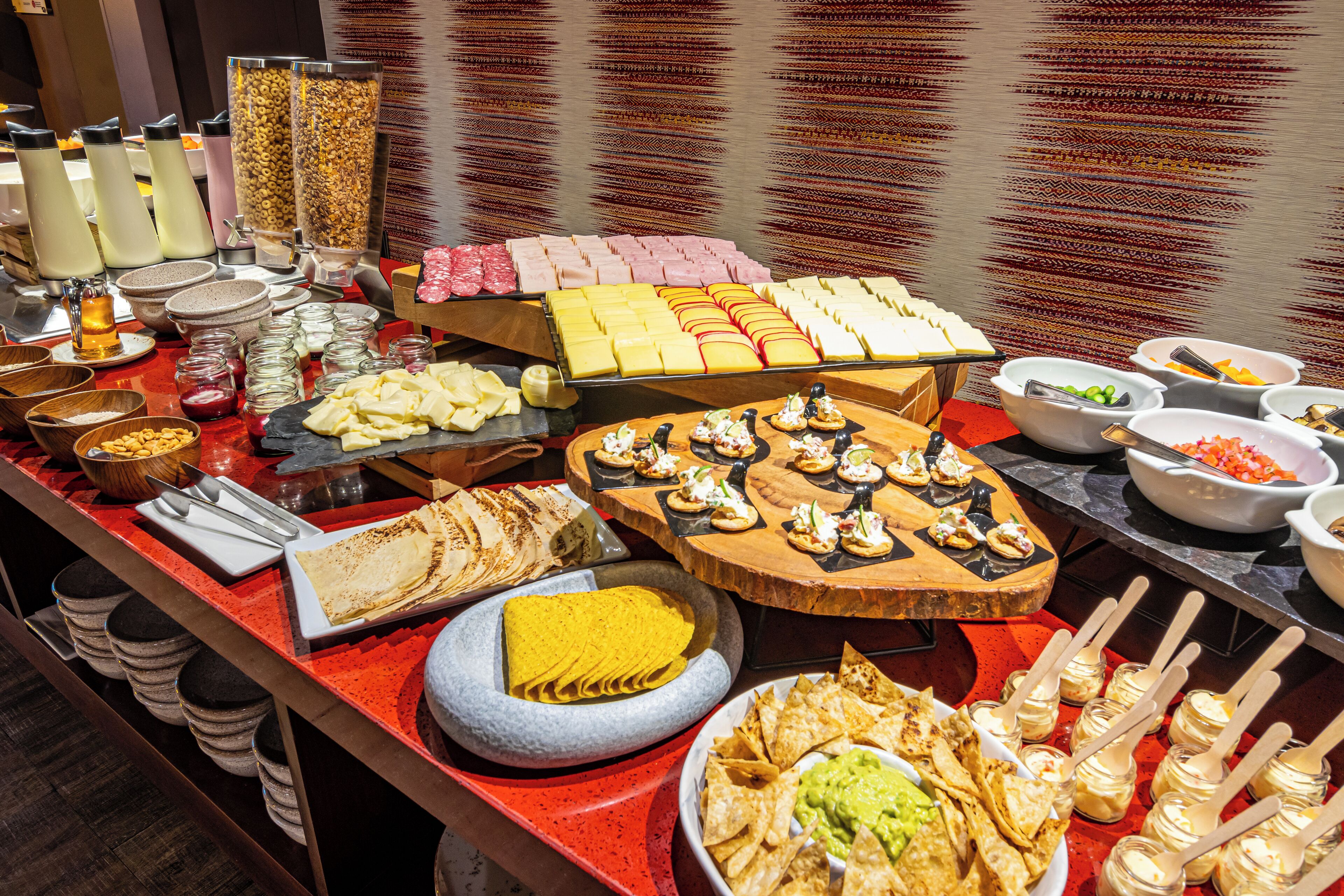 A buffet with various food items including tortillas, chips, and dips.