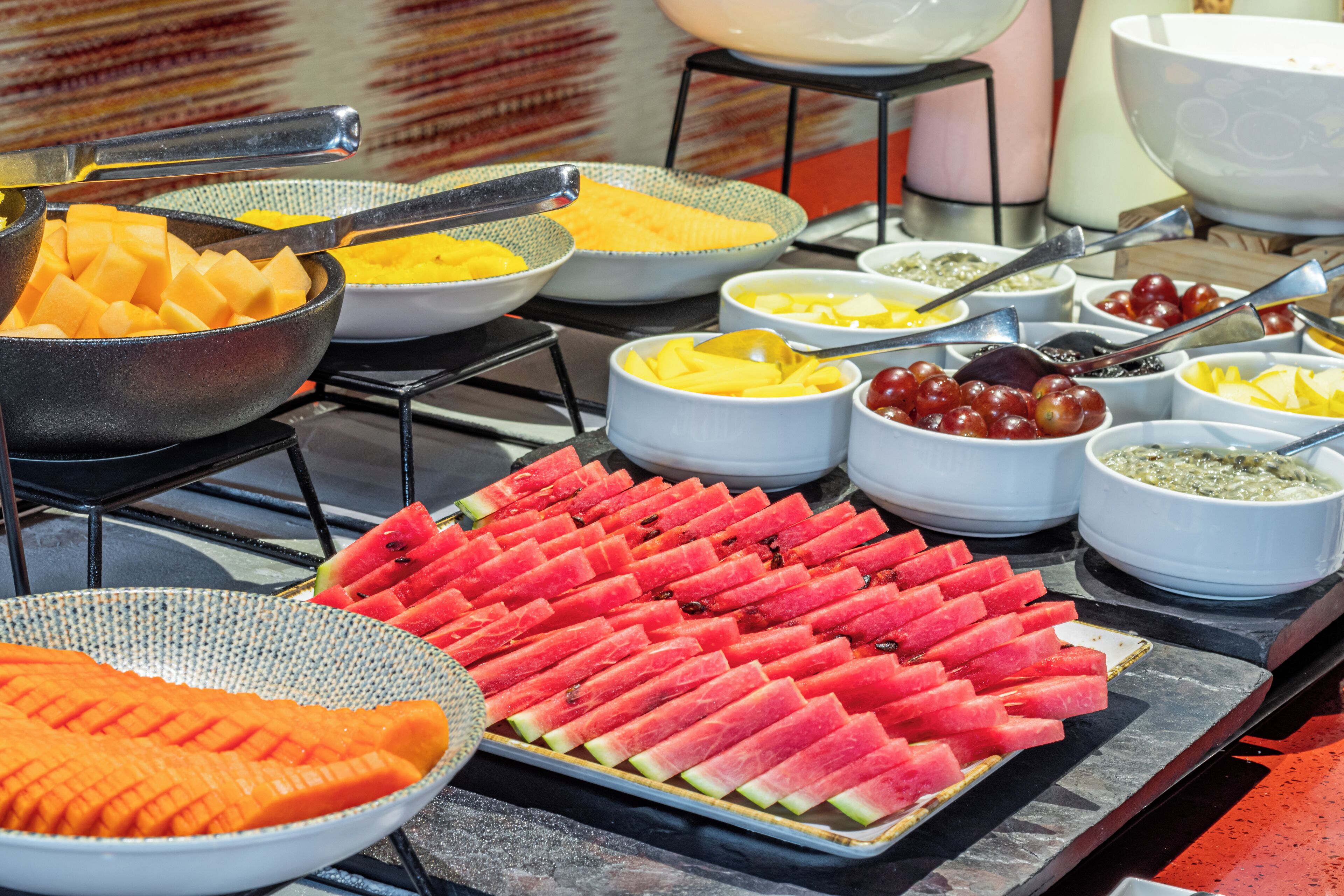 A buffet with various fruits and condiments.