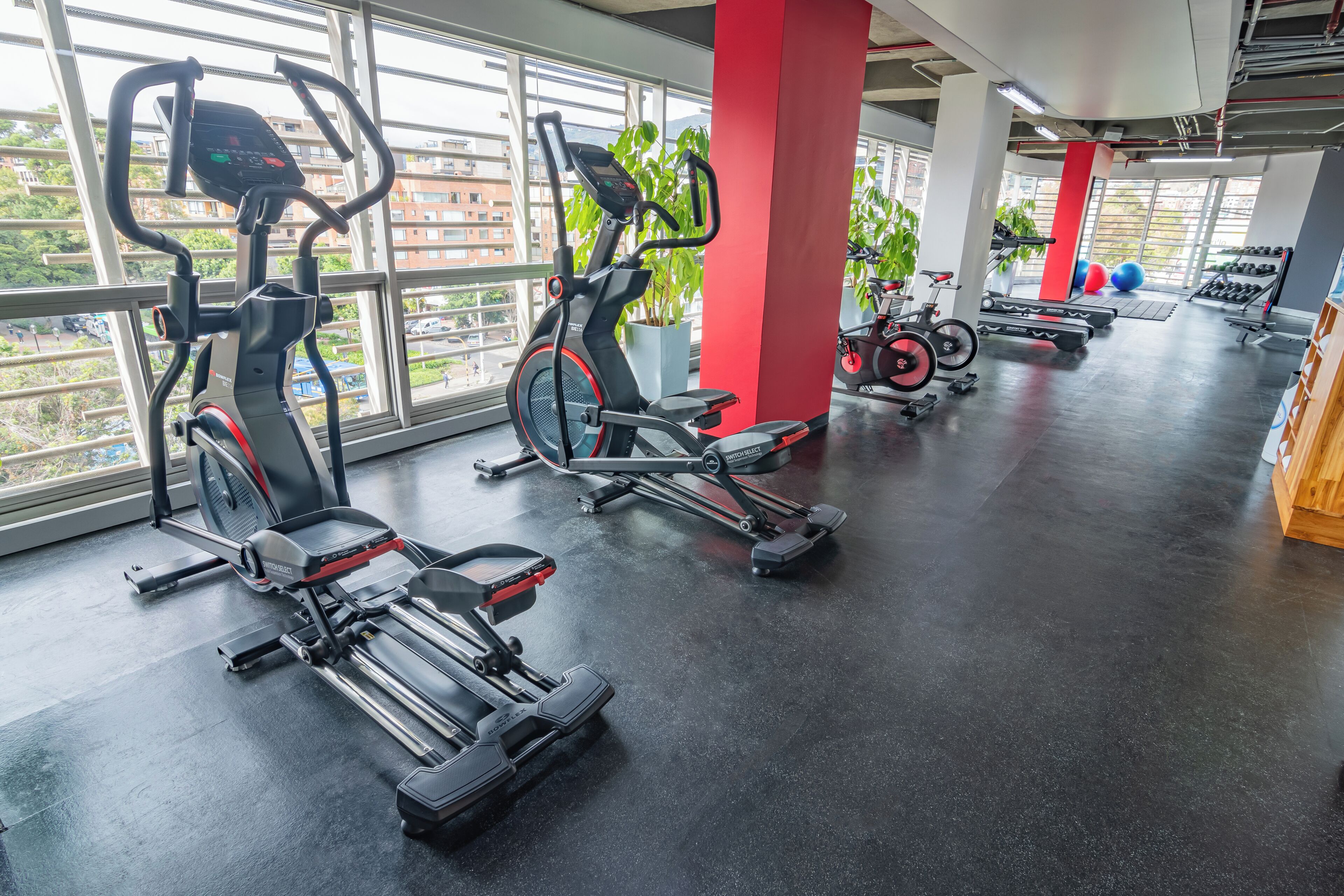 Ein Fitnessstudio mit Ergometer, Laufbändern und Gewichten.