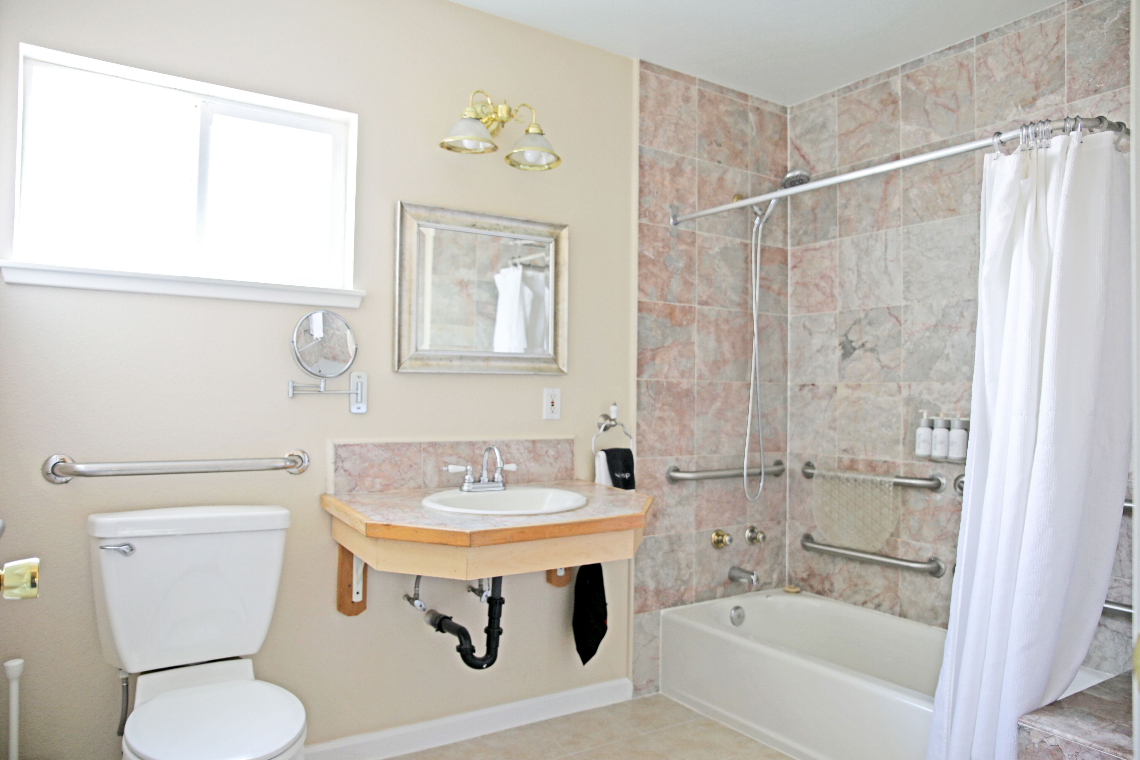 A bathroom with a toilet, sink, shower, and bathtub.
