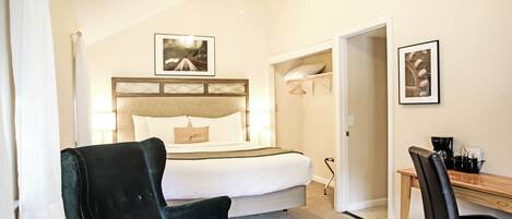 A hotel room with a bed, a desk, a chair, and a ceiling fan.