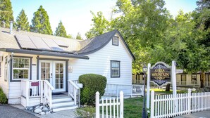 A white building with a sign reading "Sierra Mountain Inn" and a white picket fence. - Sierra Mountain Inn (Grass Valley)