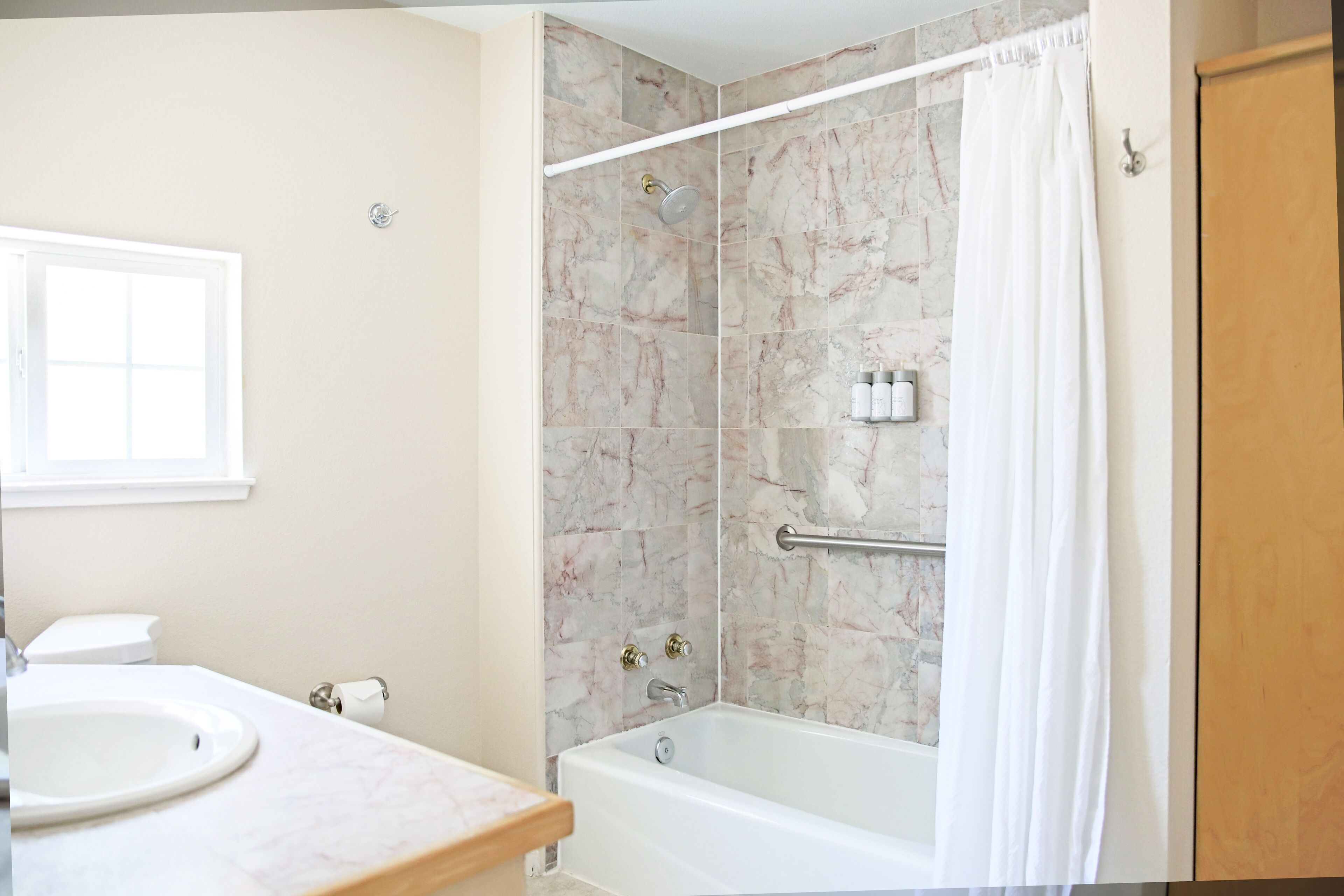 A bathroom with a bathtub, a shower, a toilet, and a sink.