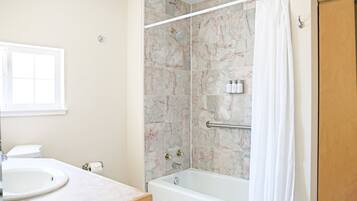 A bathroom with a bathtub, a shower, a toilet, and a sink.