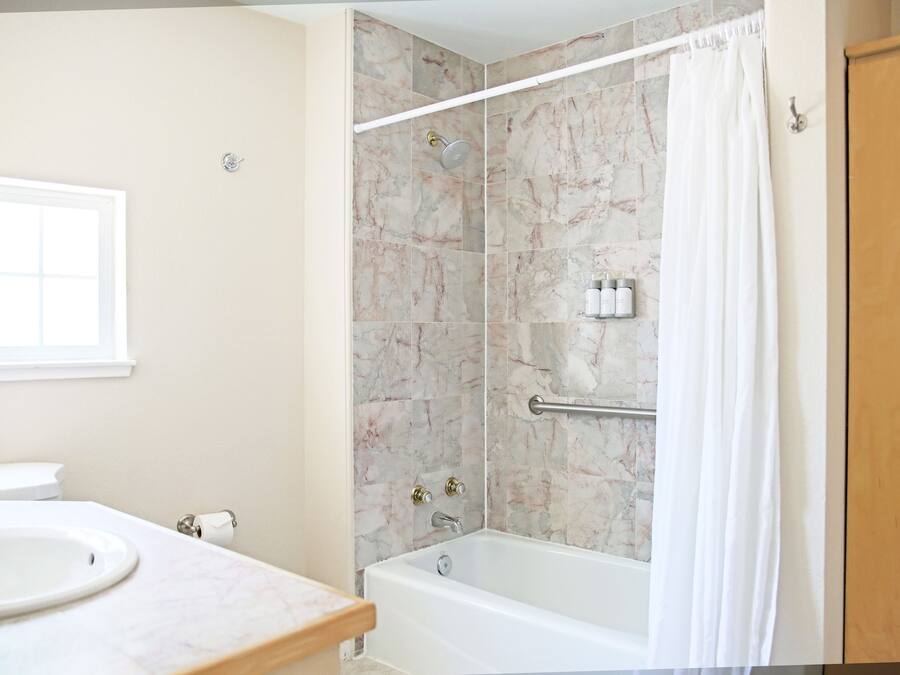 A bathroom with a bathtub, a shower, a toilet, and a sink.