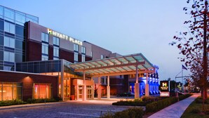 A modern hotel with a glass facade, a covered entrance, and a sign indicating it is a Hyatt Place. - Hyatt Place Long Island East End (Riverhead)