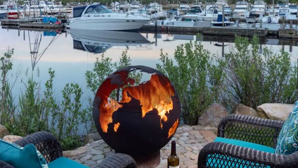 A marina with boats docked, a globe sculpture, wicker furniture, and a bottle of wine on a table. - Hyatt Place Long Island East End (Riverhead)
