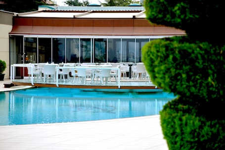Una piscina al aire libre de temporada, sombrillas