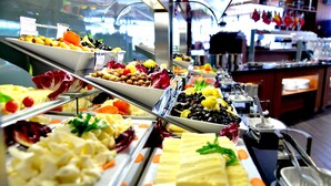 Un buffet proposant une variété de plats, notamment des salades, des fromages et des fruits.