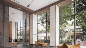 A modern lounge area with large windows, a tiled floor, and wooden seating. - Courtyard by Marriott Phnom Penh (Phnom Penh)