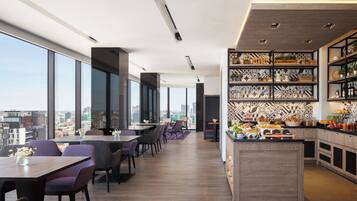 A modern restaurant with high ceilings, large windows, and a city view.