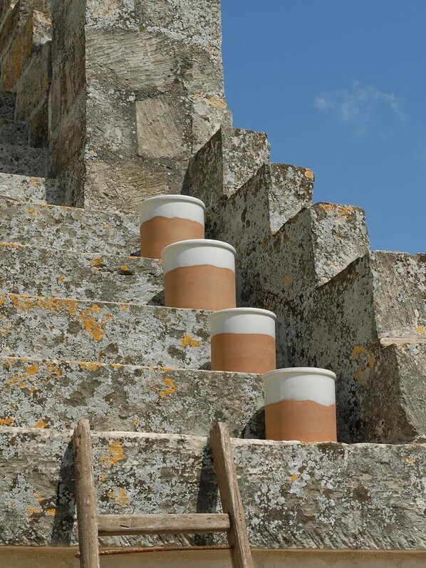 A set of stone steps with three cylindrical objects placed on them. - Corte dei Francesi (Maglie)
