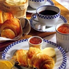 A table with croissants, coffee cups, and a bowl of soup. - Gaia Wellness Residence Hotel (Mezzana)