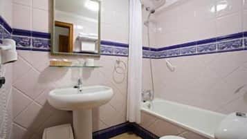 Een badkamer met een wastafel, spiegel, douche en toilet.