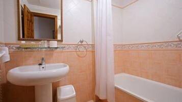 Un baño con lavabo, espejo y bañera.