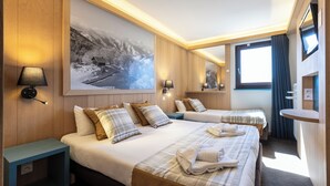 A hotel room with two beds, a large painting, a TV, and a small table. - Hôtel Club MMV Les Bergers (Huez)
