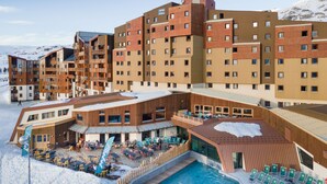 A modern hotel with multiple floors, outdoor pool, and ski lift in the background. - Hôtel Club MMV Les Bergers (Huez)
