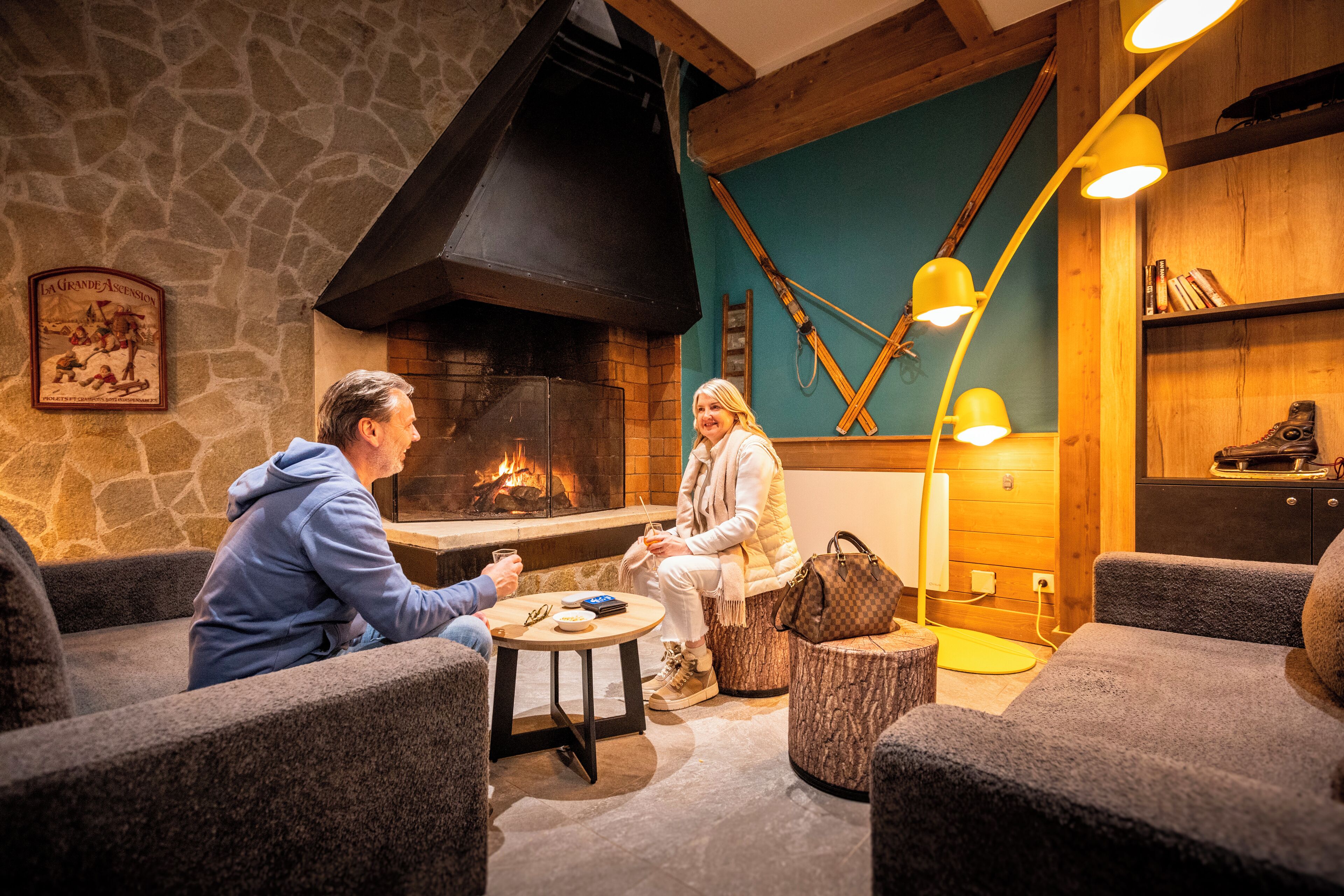 Un interior acogedor con paredes de piedra, chimenea y mobiliario de madera.
