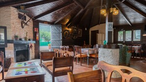 A rustic interior with wooden furniture, a fireplace, and a bicycle mounted on the wall. - Residencial Turístico Vega-Sierra (Bogarra)