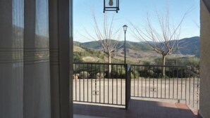 A view from a balcony with a metal gate, a hanging lantern, and a mountain landscape in the background. - Residencial Turístico Vega-Sierra (Bogarra)