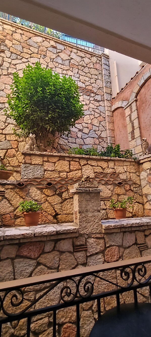 Un muro de piedra con una planta en maceta y una pequeña fuente.
