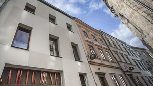 A multi-story building with a modern facade, a visible sign for 'ARICON', and classic architectural elements on the corner. - OREA Hotel Arigone Olomouc (Olomouc)