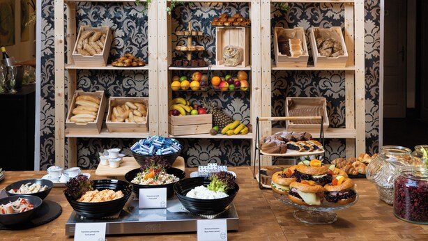 A buffet with various food items and a decorative wall in the background. - OREA Hotel Arigone Olomouc (Olomouc)