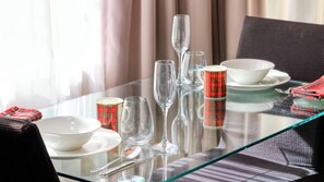 A dining table with clear glassware, a plaid mug, and a bowl set for a meal. - Mt Tamborine Stonehaven Manor (Tamborine Mountain)