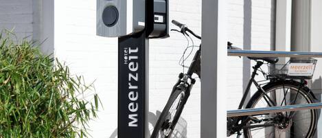 Een fietsenrek met een bord waarop 'Meerzeit Hotel' staat.