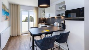 Una cocina moderna con una isla central, taburetes de bar y un microondas integrado.