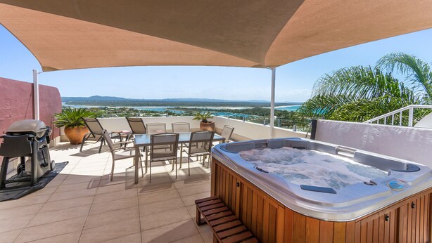 A rooftop patio with a hot tub, outdoor seating, and a view of the ocean. - Bali Hai Apartments Noosa (Noosa Heads)