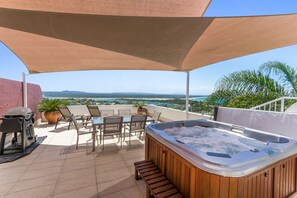 A rooftop patio with a hot tub, outdoor seating, and a view of the ocean. - Bali Hai Apartments Noosa (Noosa Heads)