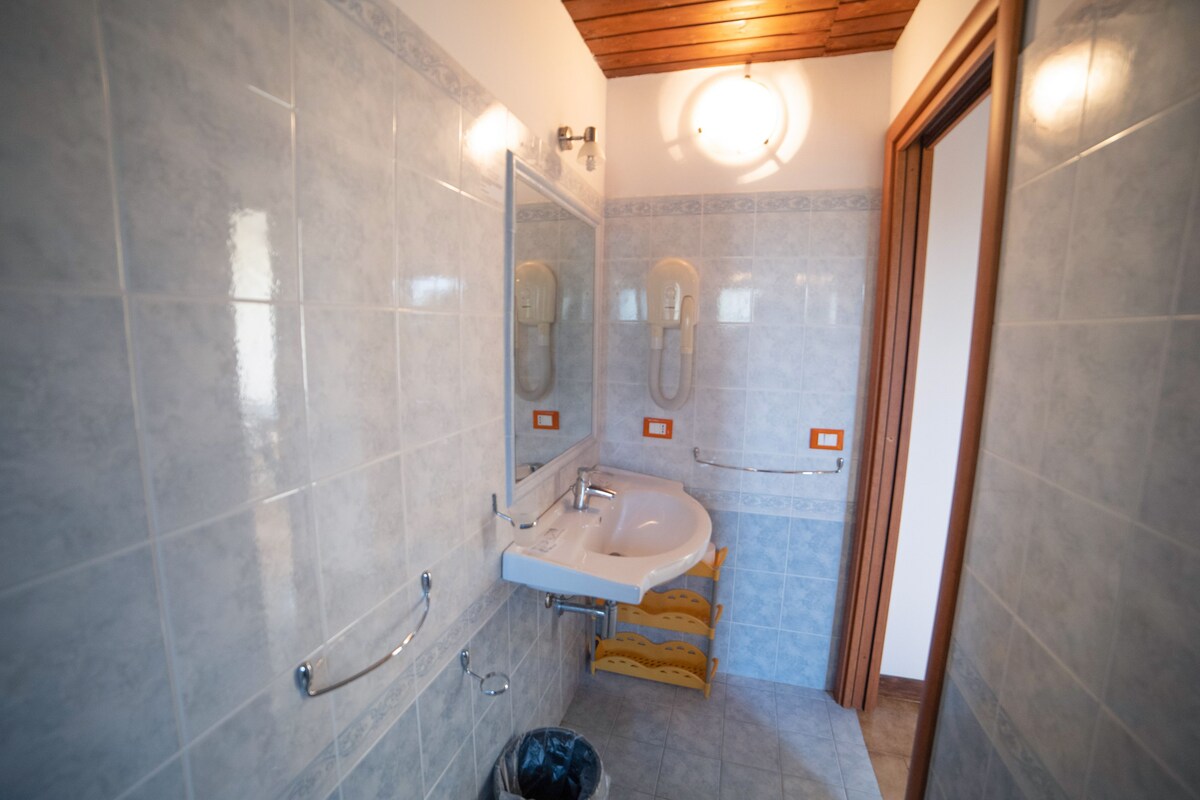 A bathroom with a sink, mirror, and towel rack.