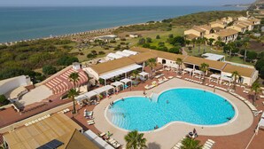 A resort with a large swimming pool, sun loungers, and a view of the ocean. - Zeta Club Sikania Eco Resort (Butera)