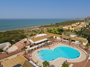 Una piscina al aire libre, sombrillas, tumbonas