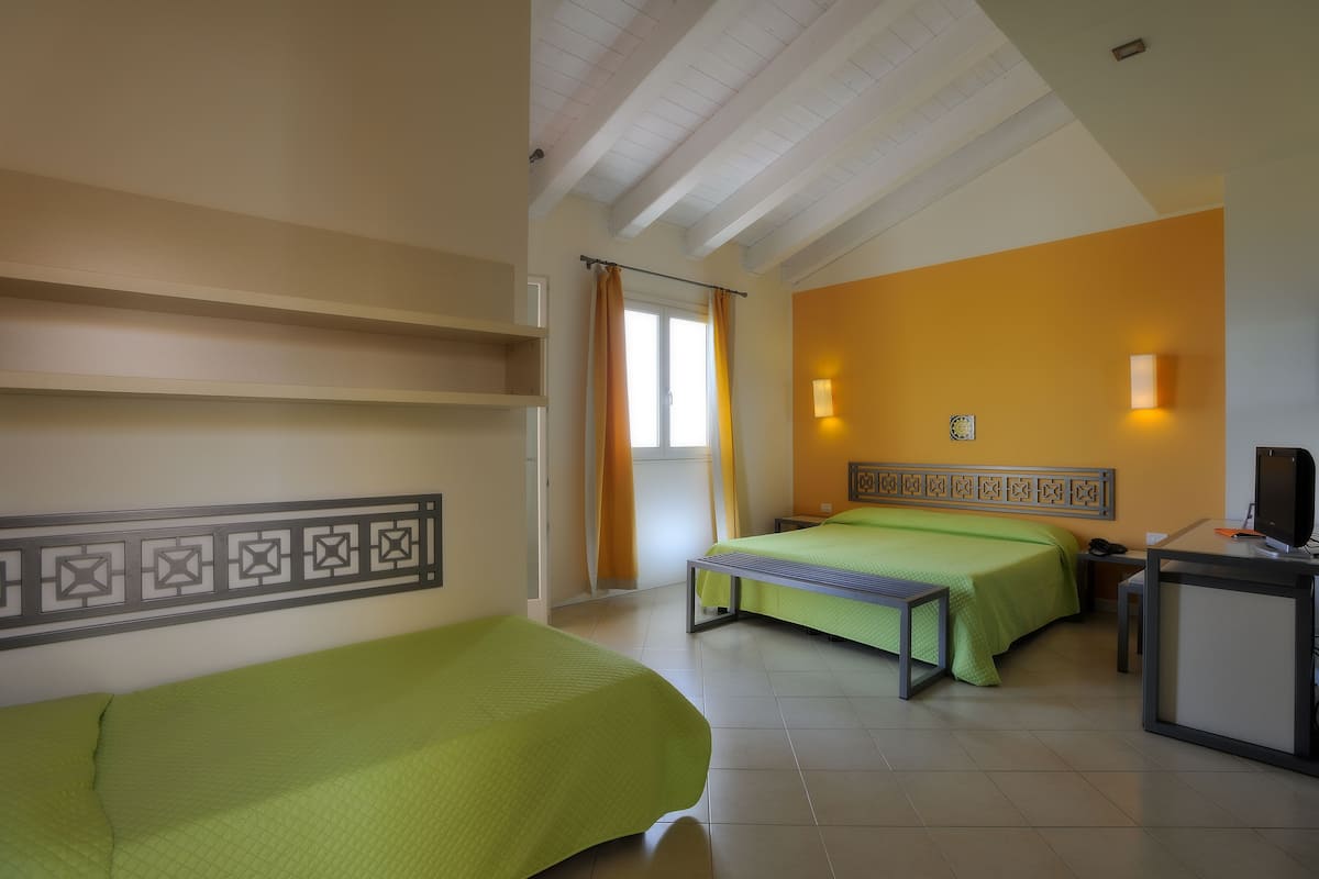 Una habitación de hotel con dos camas, un escritorio y una silla.