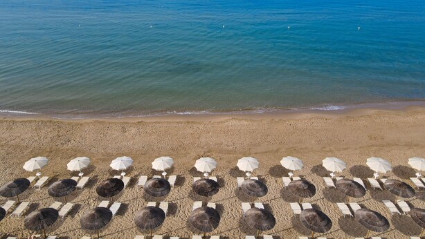 A beach with rows of sun loungers and umbrellas, a sandy shore, and the ocean in the background. - Zeta Club Sikania Eco Resort (Butera)