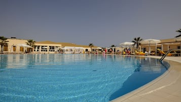 Een buitenzwembad, parasols voor strand/zwembad