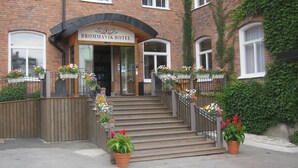 The entrance to Brommavik Hotel with a wooden staircase, flower boxes, and a brick facade. - Brommavik Hotel (Bromma)