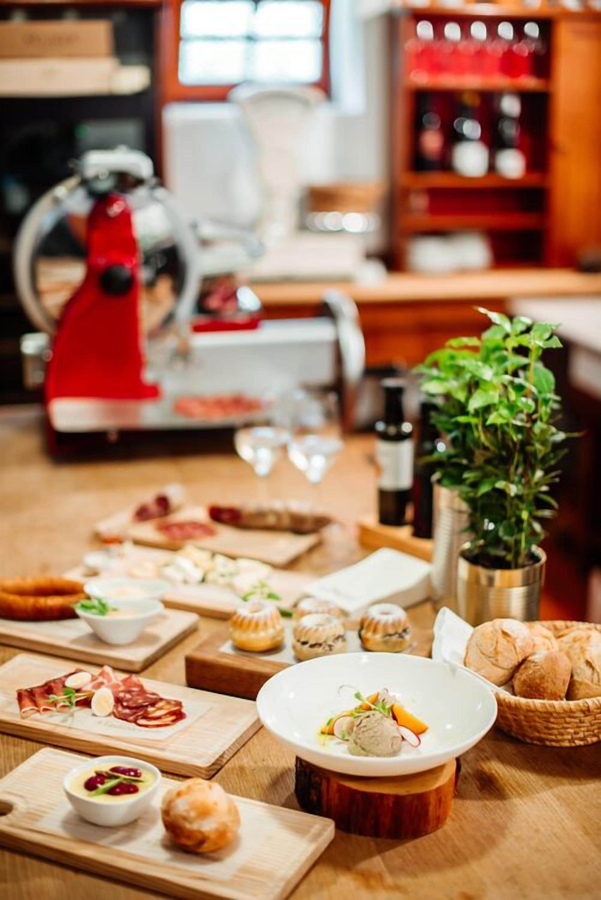 A table set with various food items, including cheeses, meats, and pastries.