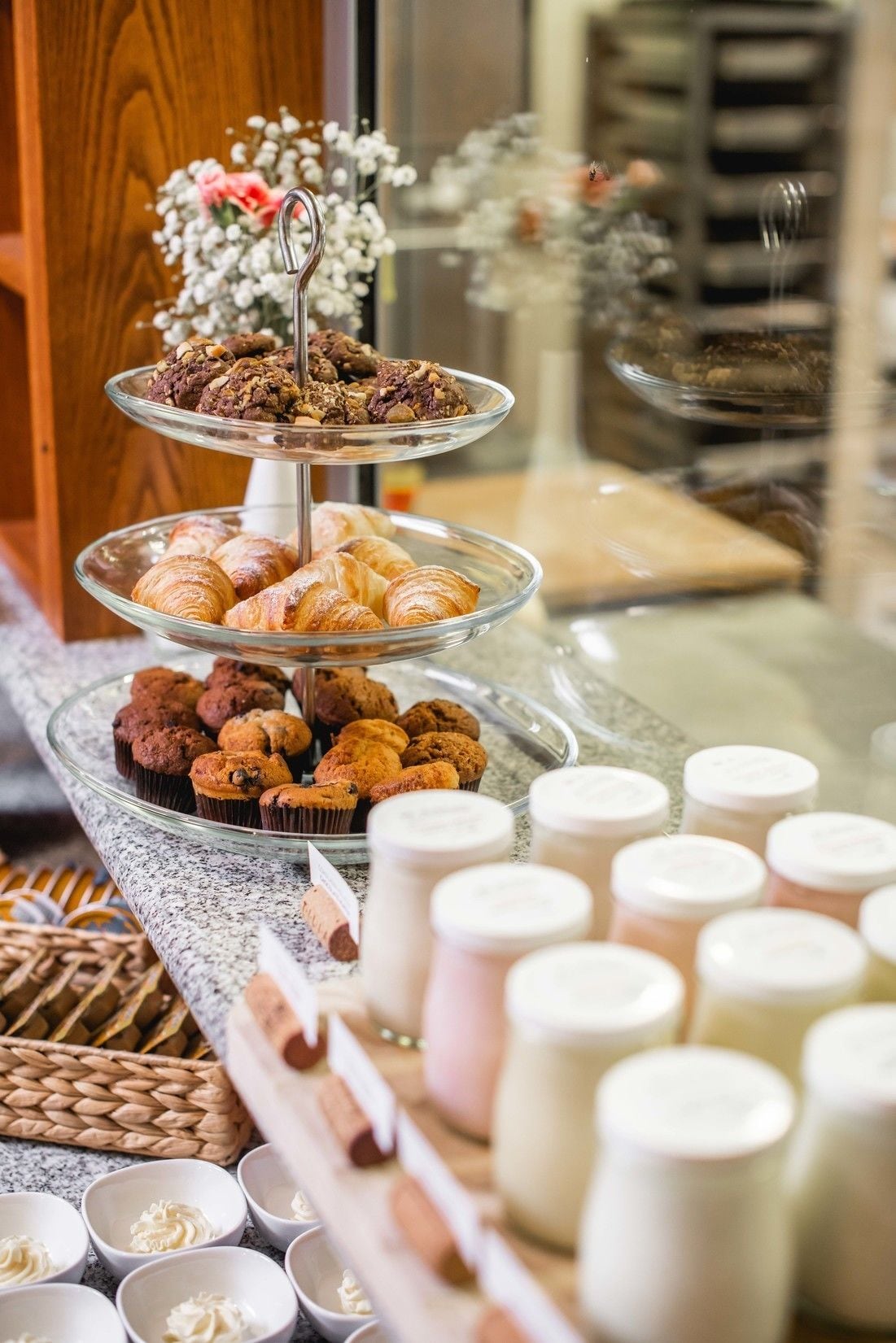 Un buffet proposant des pâtisseries, des muffins et des pots de crème.