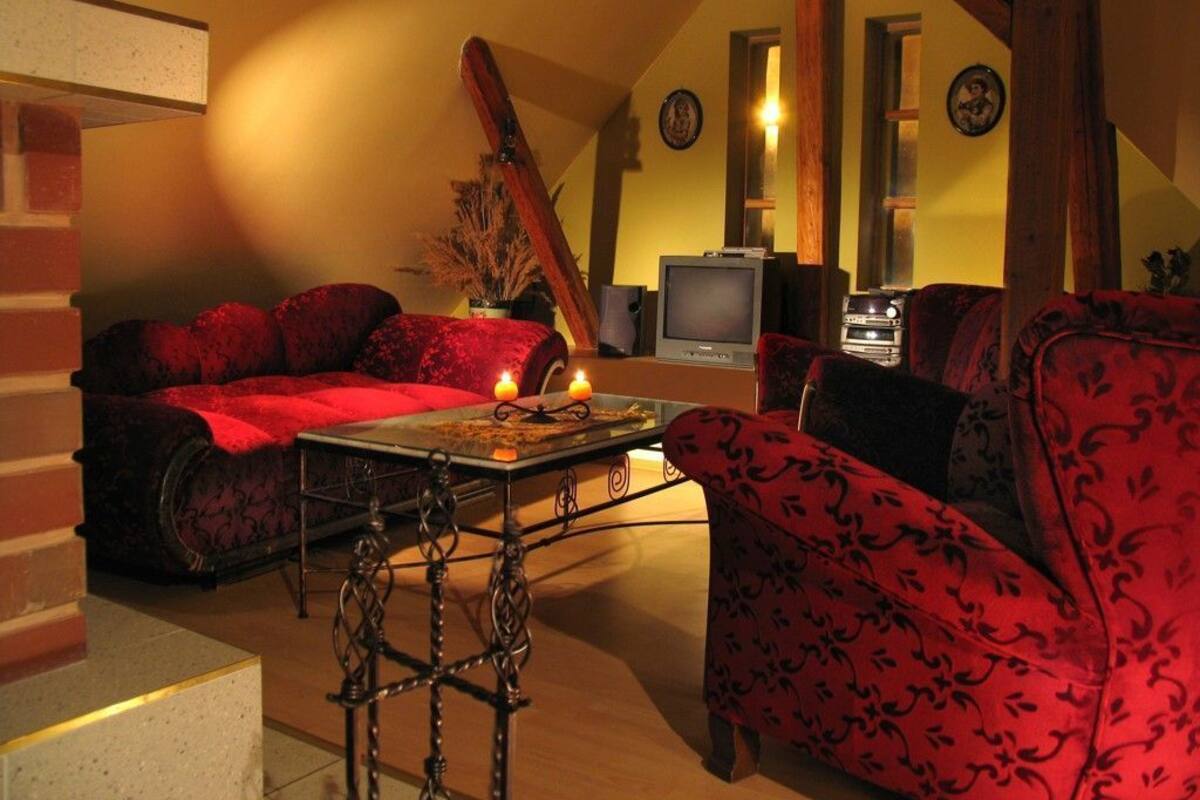 Ein gemütliches Wohnzimmer mit roter Polstermöbeln, einem Fernseher und einem Kamin.