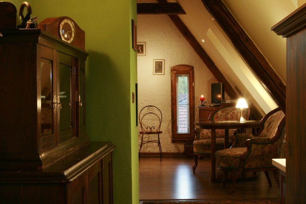 A cozy room with a wooden cabinet, a desk with a lamp, and a chair.