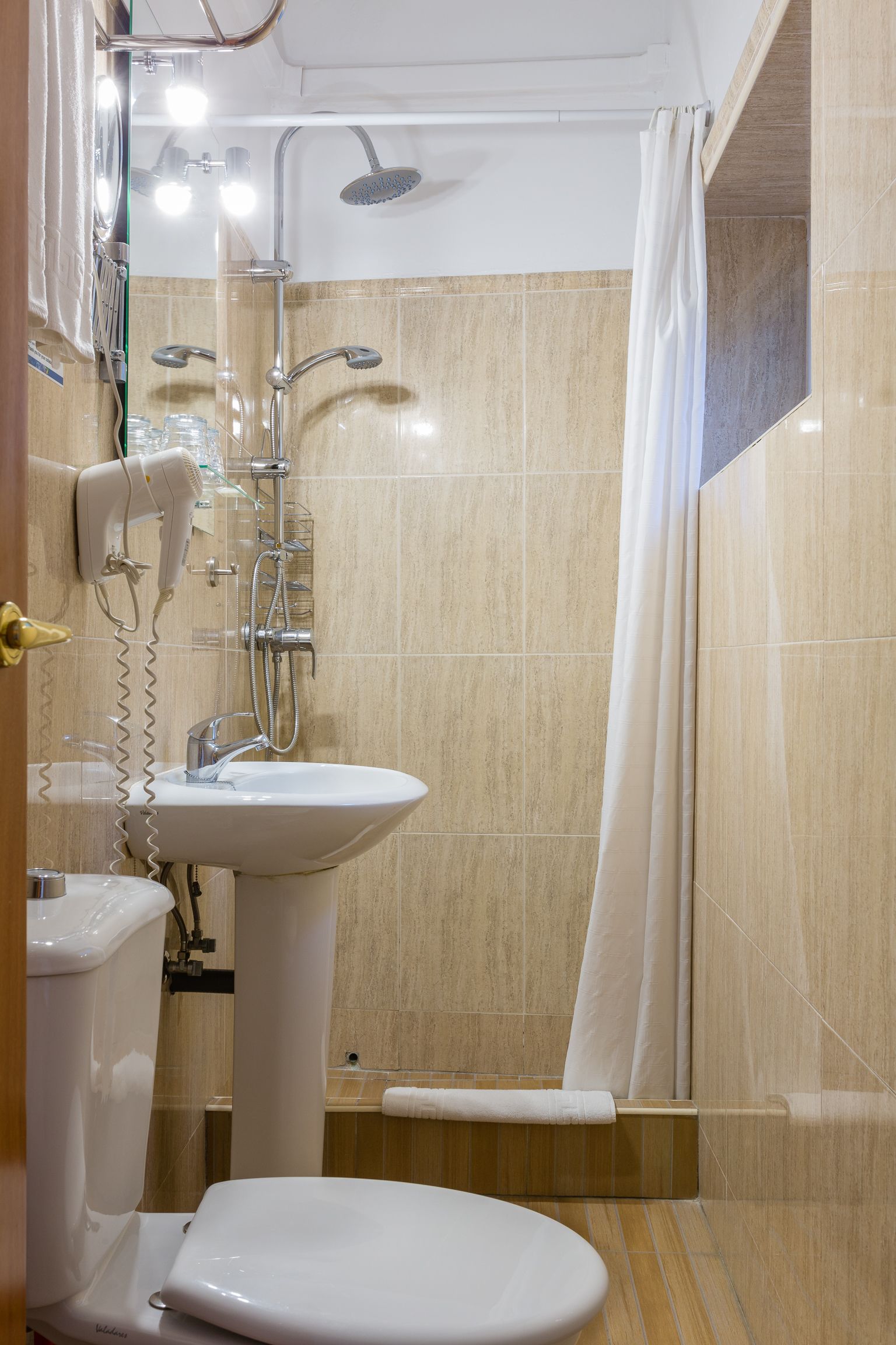 A modern bathroom with a sink, toilet, and shower area.