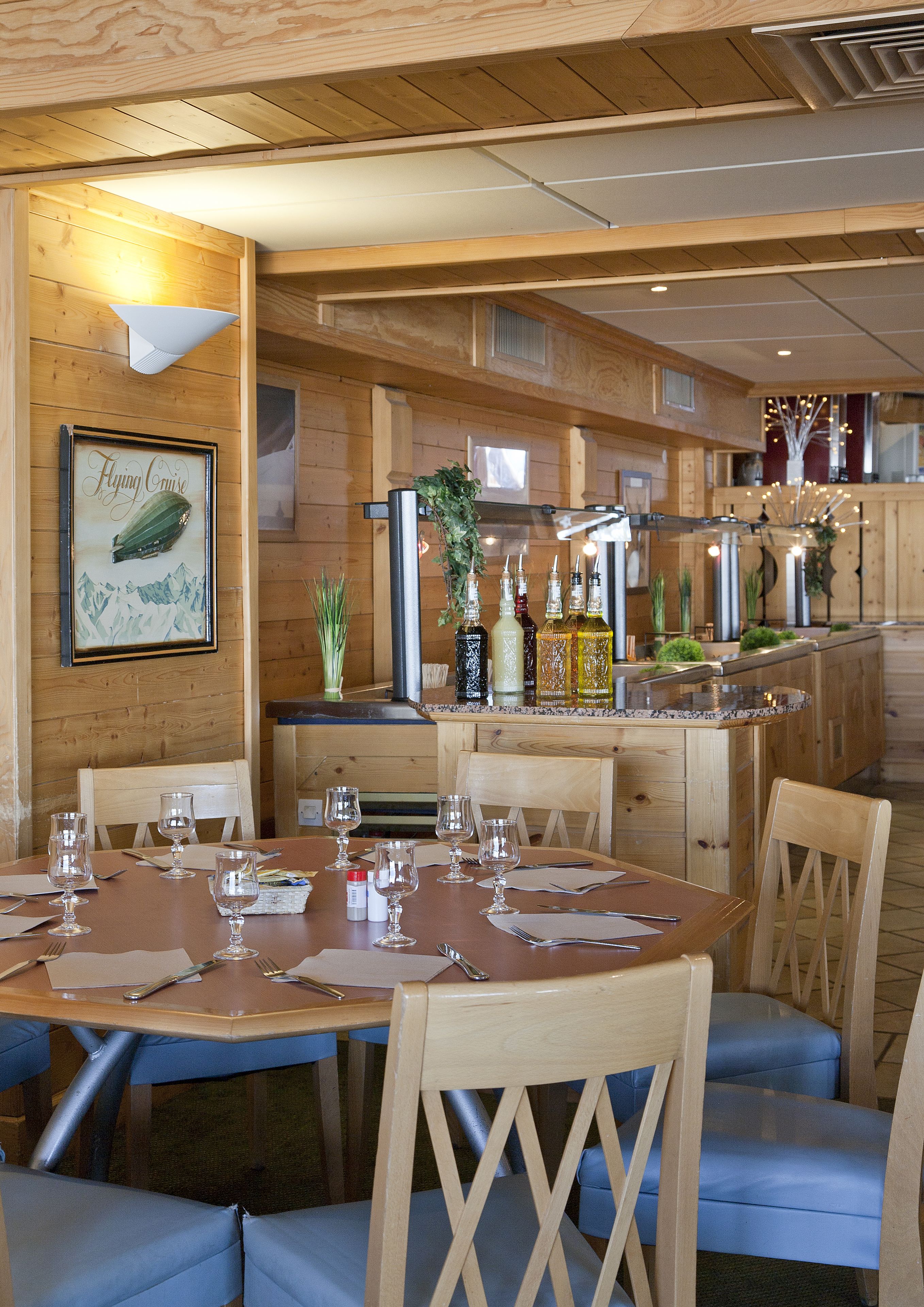 A wooden interior with a dining area, bar, and kitchen.
