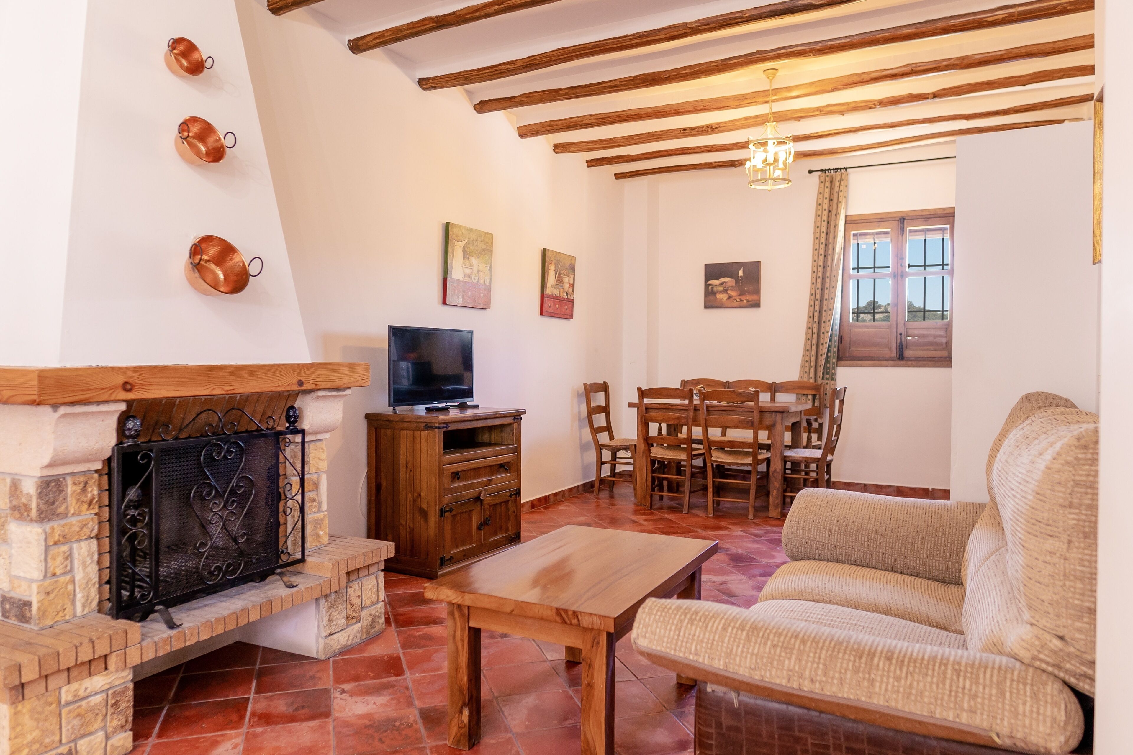 A living room with a fireplace, wooden furniture, and a television.