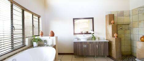 A modern bathroom with a freestanding bathtub, a vanity with a mirror, and a shower area.