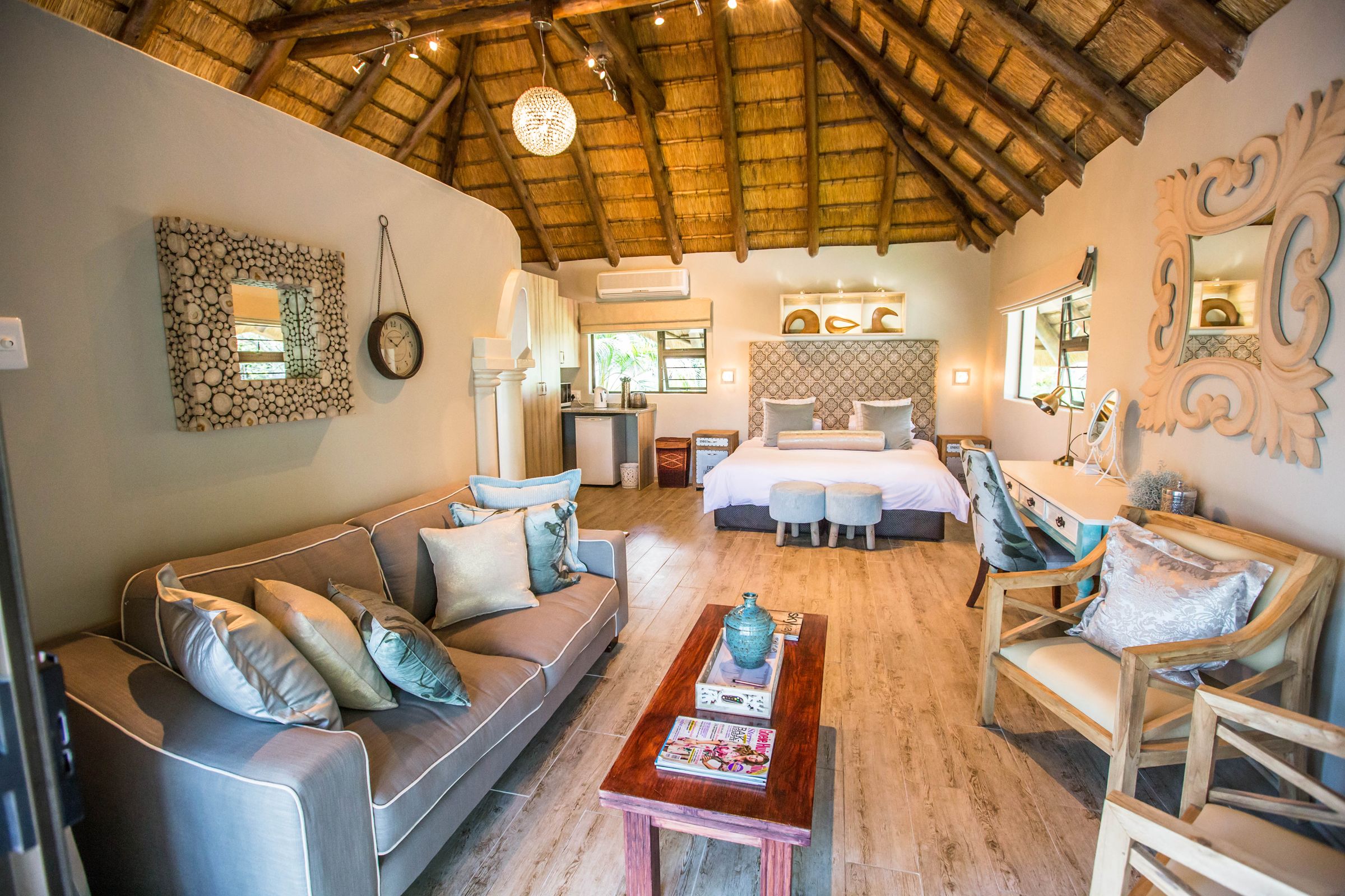 A spacious room with a high ceiling, a bed, a sofa, and a dining area.