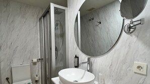A bathroom with a white sink, a toilet, and a glass shower enclosure. - IRAIPE GORBEA HOTEL (Vitoria-Gasteiz)